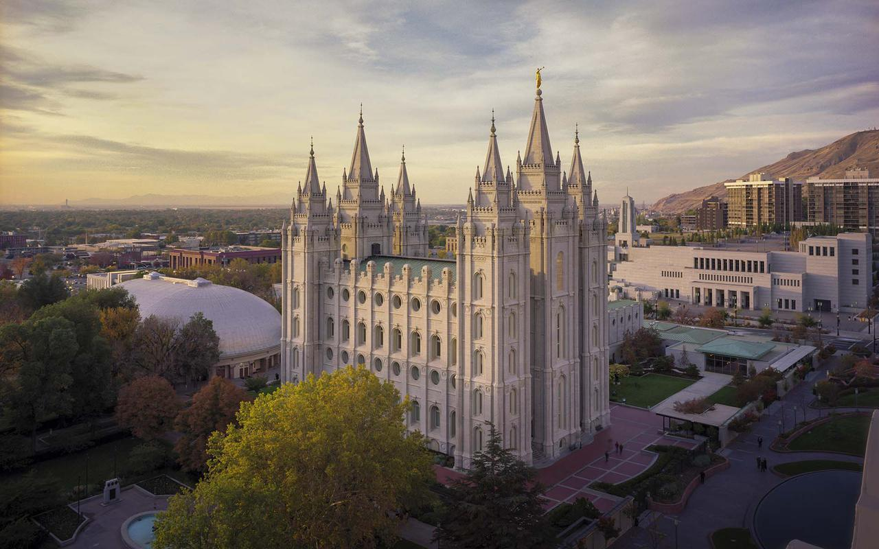 The Salt Lake Temple with its six spires against a blue sky.